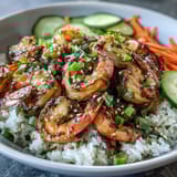 Sliced cucumber, julienned carrot, and edamame create colorful texture on a healthy rice bowl with ginger-sesame dressing.