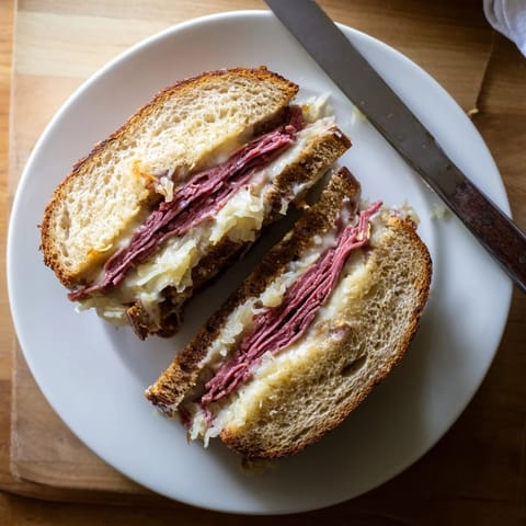 A classic Reuben Sandwich sizzling in a skillet, with crispy crusts and steam rising, served with crunchy potato chips and dill pickles.