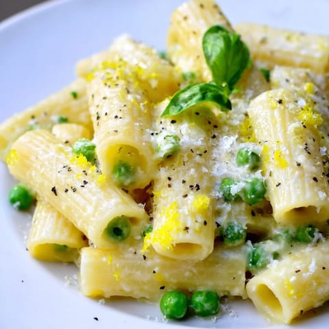 Steaming bowls of pea and lemon ricotta pasta feature tender rigatoni tossed with a silky sauce and finished with fresh herbs.
