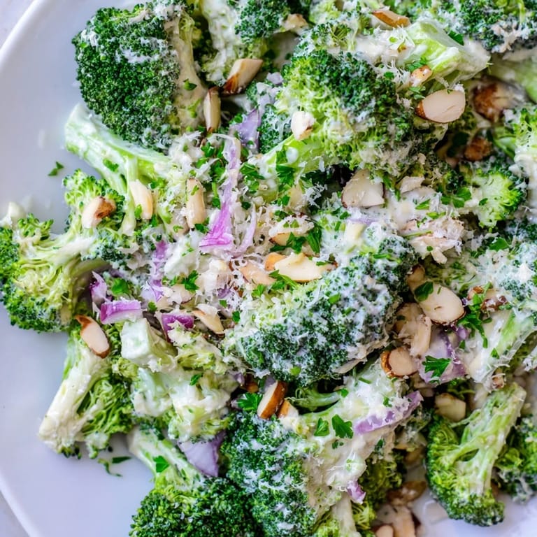 Garlic Parmesan Broccoli Salad served in a white bowl, garnished with parsley and extra Parmesan, perfect as a healthy side dish.